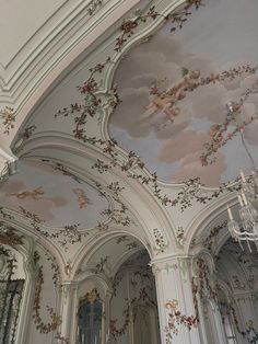 the ceiling is painted with flowers and birds on it's walls, along with chandeliers