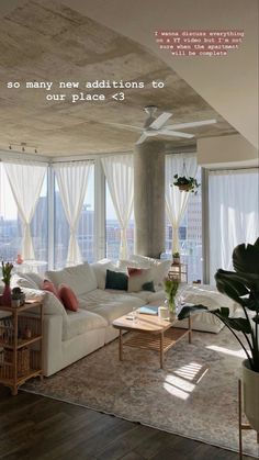 a living room filled with lots of furniture next to large windows on top of a wooden floor