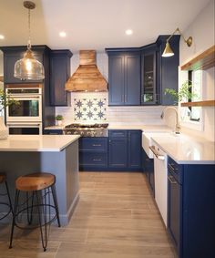 a kitchen with blue cabinets and white counter tops