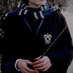 a young man holding a harry potter wand in his hands