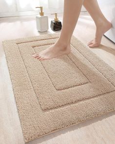 a woman's bare feet standing on a bathroom rug