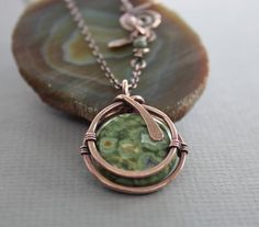 a necklace with a green pendant on it