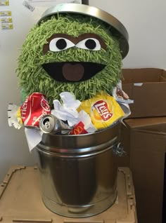 the sesame street character is sitting in a trash can filled with candy bars and soda cans