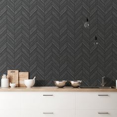 a kitchen with black and white herringbone wallpaper on the walls, counter tops and drawers