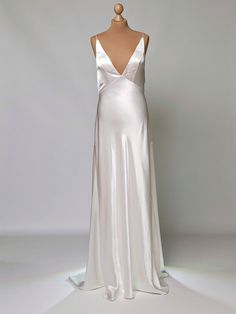 a white dress on a mannequin with a backless top and long skirt