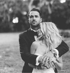 a bride and groom hugging each other in black and white