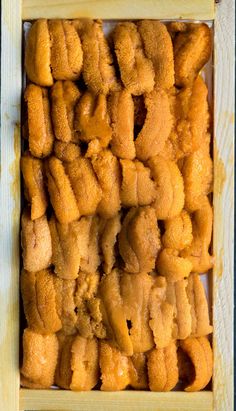 a wooden box filled with lots of doughnuts