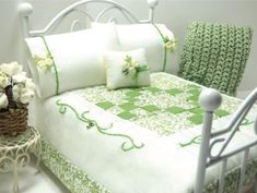 a white bed with green and white bedspread