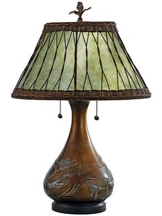 a lamp that is on top of a wooden base with a green shade over it