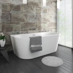 a white bath tub sitting on top of a hard wood floor next to a window