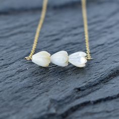 Beautiful, dainty mother of pearl Pikake carved beads in our very popular bar style. The soft, delicate white color is so pretty and pairs perfectly with any outfit. Your choice of sterling silver or gold fill. This chain will not tarnish and can even get wet! Delicate Mother Of Pearl Necklace For Wedding, Gold Single Strand Mother Of Pearl Jewelry, Dainty Mother Of Pearl Jewelry With Pearl Charm, Delicate White Mother Of Pearl Necklace, Pearl Bar Necklace, Adjustable Shell-shaped Mother Of Pearl Necklace, Adjustable Shell-shaped Mother Of Pearl Jewelry, Pearl Bangle, Bar Styling