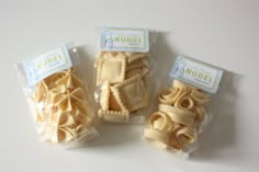 three packaged packages of pasta noodles on a white surface