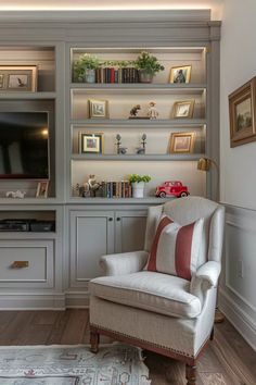 a white chair sitting in front of a tv on top of a wooden shelf filled with books