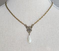 "This beautiful necklace features a beautiful brass filigree pendant with glass pearl teardrop. The necklace is reminiscent of pieces seen in classic portraits of the past. It hangs 16 1/2 \" long from a nickel free brass chain with lobster clasp and has a 2\" long extender chain with glass pearl detailing. Comes in a lovely gift box with ribbon. In the Eighteenth and Nineteenth centuries necklaces were very fashionable. Some were made of pearls, glass or gemstones and can be seen in many classic portraits. I think they're a very elegant accessory." Elegant Antique Gold Pendant Necklace, Wedding Filigree Teardrop Necklace, Vintage Drop Necklace For Formal Occasions, Victorian Pearl Necklace For Formal Occasions, Elegant Pendant Necklaces With Historical Design, Elegant Antique Finish Necklaces For Gifts, Elegant Antique Finish Pendant Necklaces, Elegant Historical Pendant Necklaces, Elegant Brass Drop Necklace For Gift