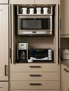 a microwave oven sitting on top of a wooden cabinet next to a cup and saucer