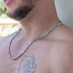 The Bellamy Stainless Steel Figaro Chain Necklace is a nod to timeless style and quiet strength. This silver-tone chain boasts a simple yet unique pattern that sets it apart. As you fasten it, the smooth texture against your skin creates a sense of understated luxury. Consider this necklace a potential staple piece in every modern man's collection – versatile, dependable, and undeniably stylish. When it comes to men’s necklaces, stainless steel brings strength, shine, and street cred to the tabl Stainless Steel Figaro Chain Necklace, Diamante Bracelet, Leather Choker Necklace, Figaro Chain Necklace, Eyebrow Piercing, Understated Luxury, Pearl Choker Necklace, Figaro Chain, Natural Stone Bracelets