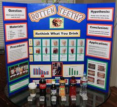 a table with posters and drinks on it that say rotten teeth, retrieving what you drink