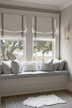 a white window seat with pillows on it