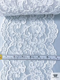 white lace with flowers on it and measuring tape