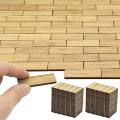 a hand holding a piece of wood next to wooden blocks