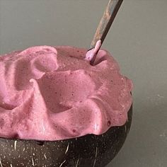 a bowl filled with pink frosting on top of a table