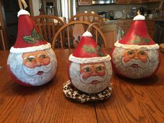 three christmas decorations sitting on top of a wooden table