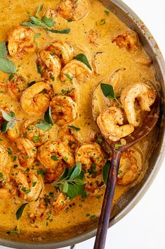 a skillet filled with shrimp and garnished with herbs