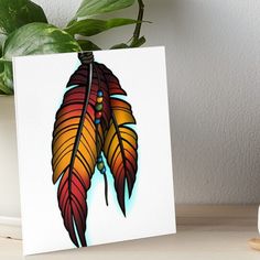 a painting of an orange and red feather on white paper art boarder next to a potted plant