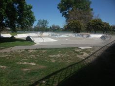 a skateboard park with ramps and trees in the background