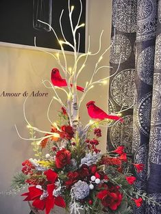 a vase filled with flowers and birds on top of a table