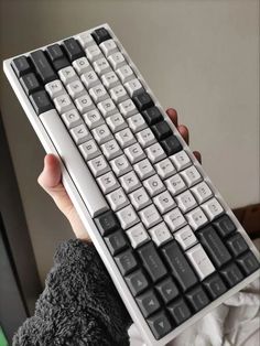 a person is holding up a computer keyboard