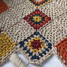 a crocheted blanket with multicolored squares on it