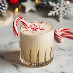 a drink with candy canes in it sitting on a table