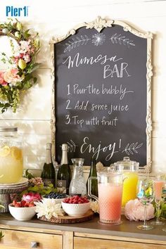 a bar with drinks and flowers on the counter next to a chalkboard sign that says dinner bar