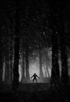 a man is running through the woods at night with his arms spread out in front of him