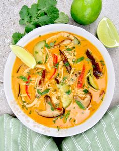 a white bowl filled with soup next to limes