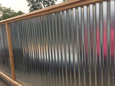 a large metal fence sitting on the side of a road