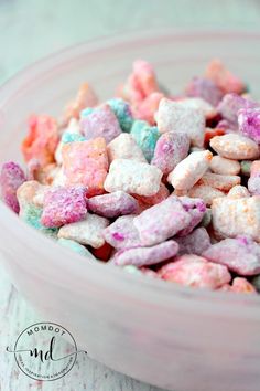 a bowl filled with pink, blue and green marshmallows on top of a table