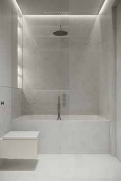 a bathroom with a white bathtub and shower head mounted to the side of the wall