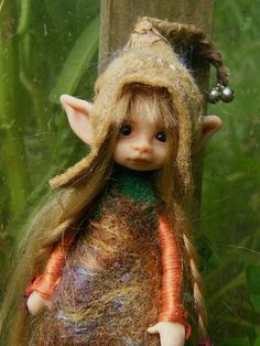 a close up of a doll with long hair and a hat on it's head