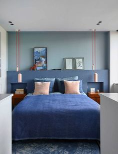 a bed with blue sheets and pillows in a bedroom