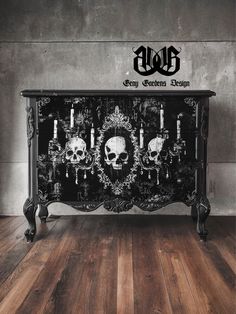 an ornate black and white cabinet with skulls on the front, candles in the back