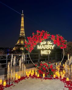 a sign that says marry me with candles in front of the eiffel tower