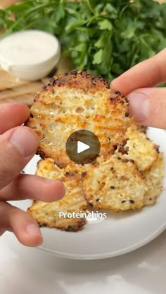 someone is holding up some food on a white plate with parsley in the background