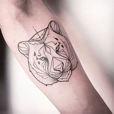 a black and white tattoo on the arm of a person with a tiger head in it