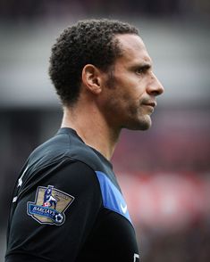 a close up of a soccer player wearing a black shirt with a blue and gold emblem on it