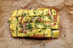 sliced up food sitting on top of a piece of brown paper covered in parsley