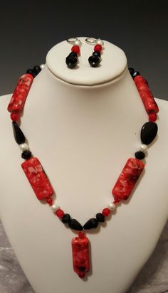 "Well, they Say the Merry Widow wore red and black and what a delightful color combination that is. This gorgeous red and black necklace with the dynamic 2 inch pendant  is definitely not for the feint of heart.   The elongated beads and pendant that are the focal point of this 22\" necklace with the 3\" extender are bold and daring. They are accompanied by red Czech crystals, white pearls and various black glass shaped beads.   The pierced hypo allergenic earrings dangle 1 ½ inches long to comp Elegant Red Beaded Necklace With Black Beads, Elegant Red And Black Beaded Necklaces, Elegant Red And Black Beaded Necklace, Red And Black Necklace, Crystals White, Lion Earrings, Merry Widow, Seahorse Necklace, Stone Statement Necklace