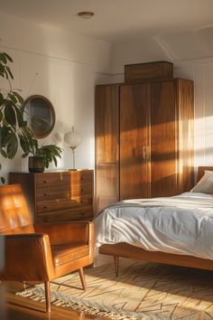 a bedroom with a bed, dresser and chair next to a plant in the corner