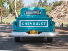 an old blue chevrolet truck is parked on the side of the road with its license plate